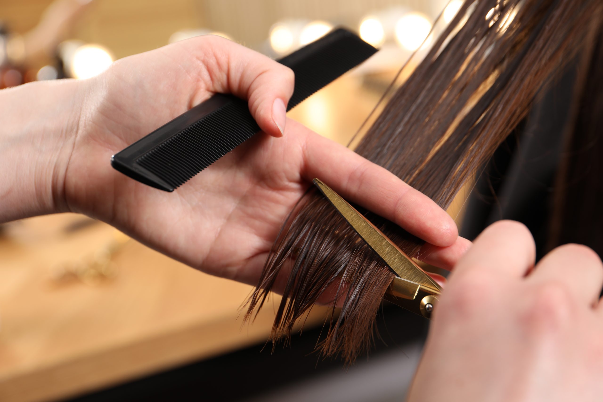 manos con tijeras cortando elcabello largo de mujer scaled